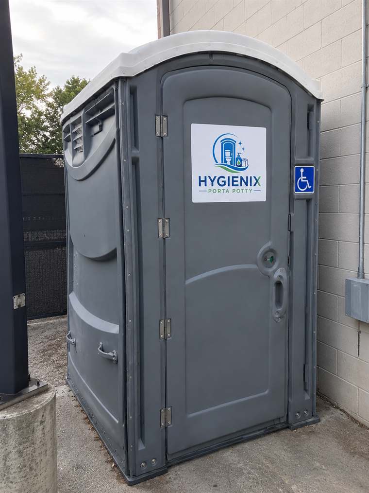Hygienix Porta Potty ADA unit against a building exterior wall