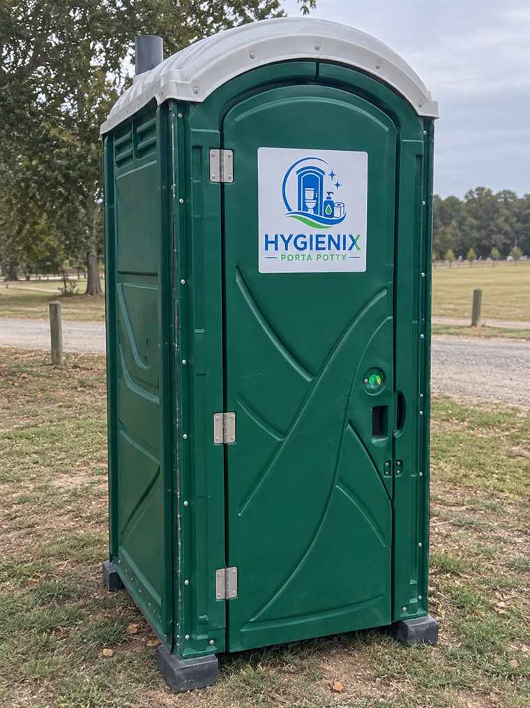 A single green Hygienix Porta Potty in an open grass field