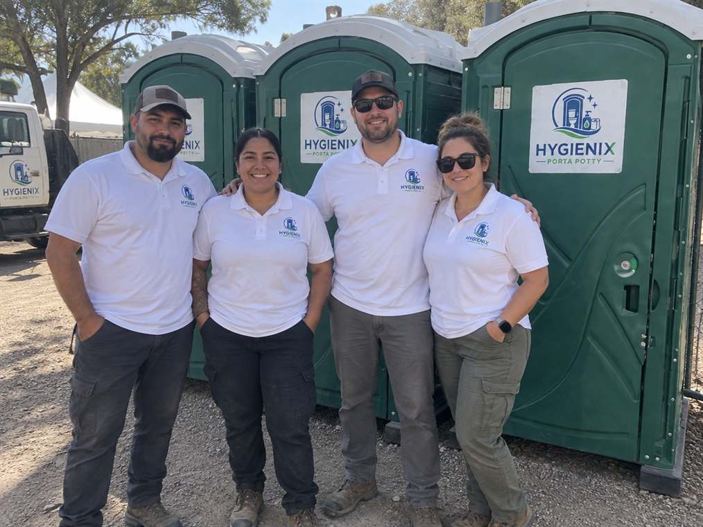 Hygienix Porta Potty crew members standing in front of delivery vehicle