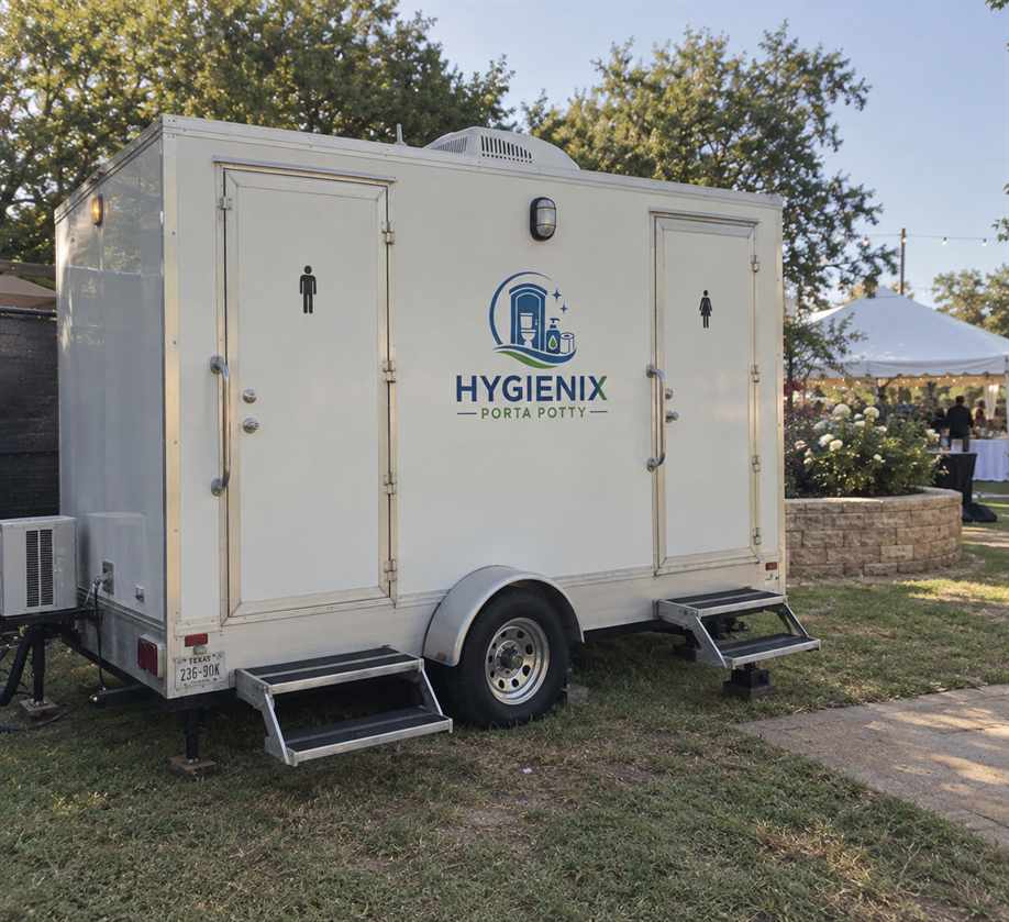 Hygienix Porta Potty restroom trailer on grass by tent