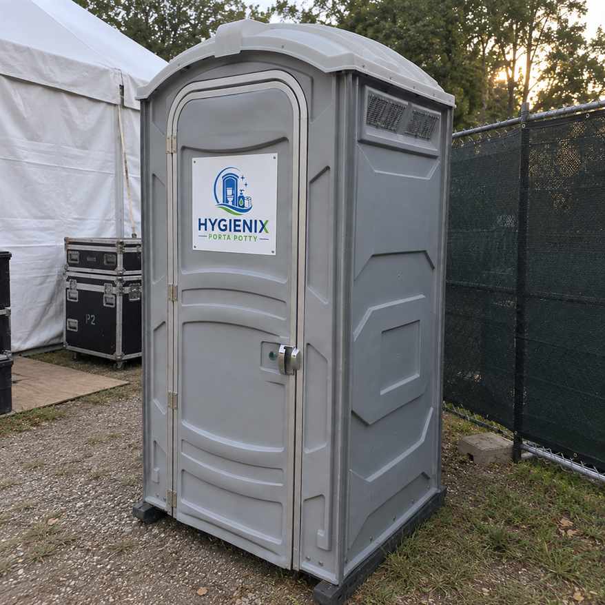 Grey Hygienix Porta Potty standard unit beside road cases